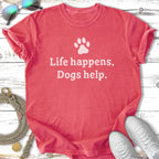 Coral t-shirt with white text: "Life happens. Dogs help." and a paw print.