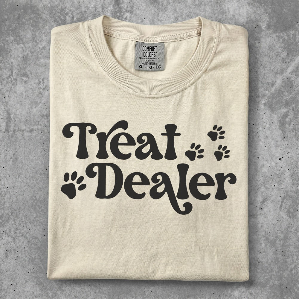 Cream t-shirt with "Treat Dealer" and paw print graphics.
