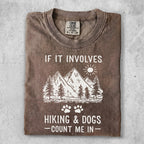 T-shirt with mountains, trees, paw prints, and text "IF IT INVOLVES HIKING & DOGS - COUNT ME IN".