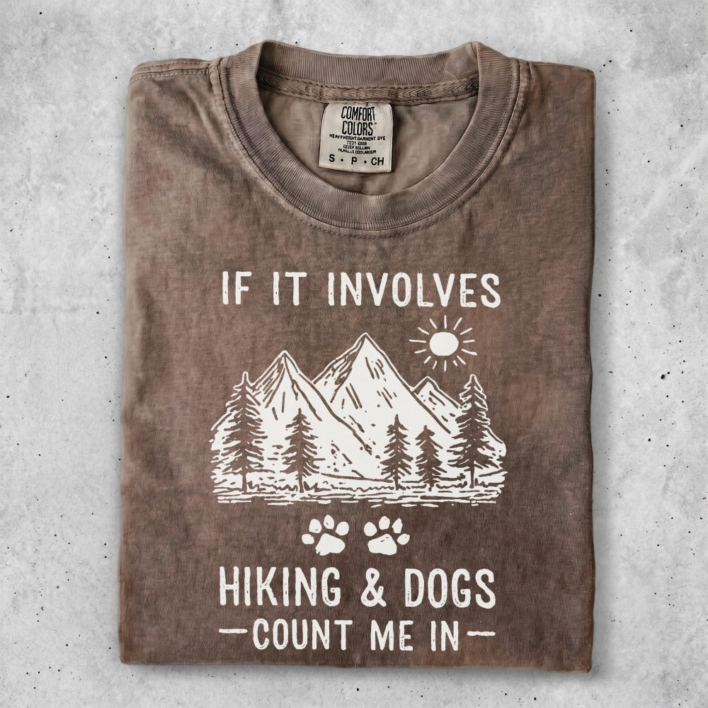 T-shirt with mountains, trees, paw prints, and text "IF IT INVOLVES HIKING & DOGS - COUNT ME IN".