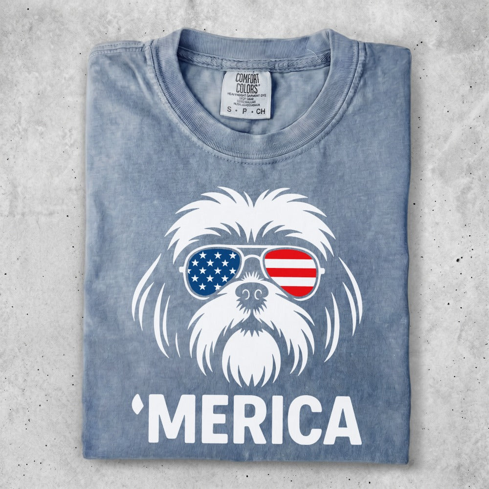 Shih tzu wearing American flag sunglasses with "Merica" text.