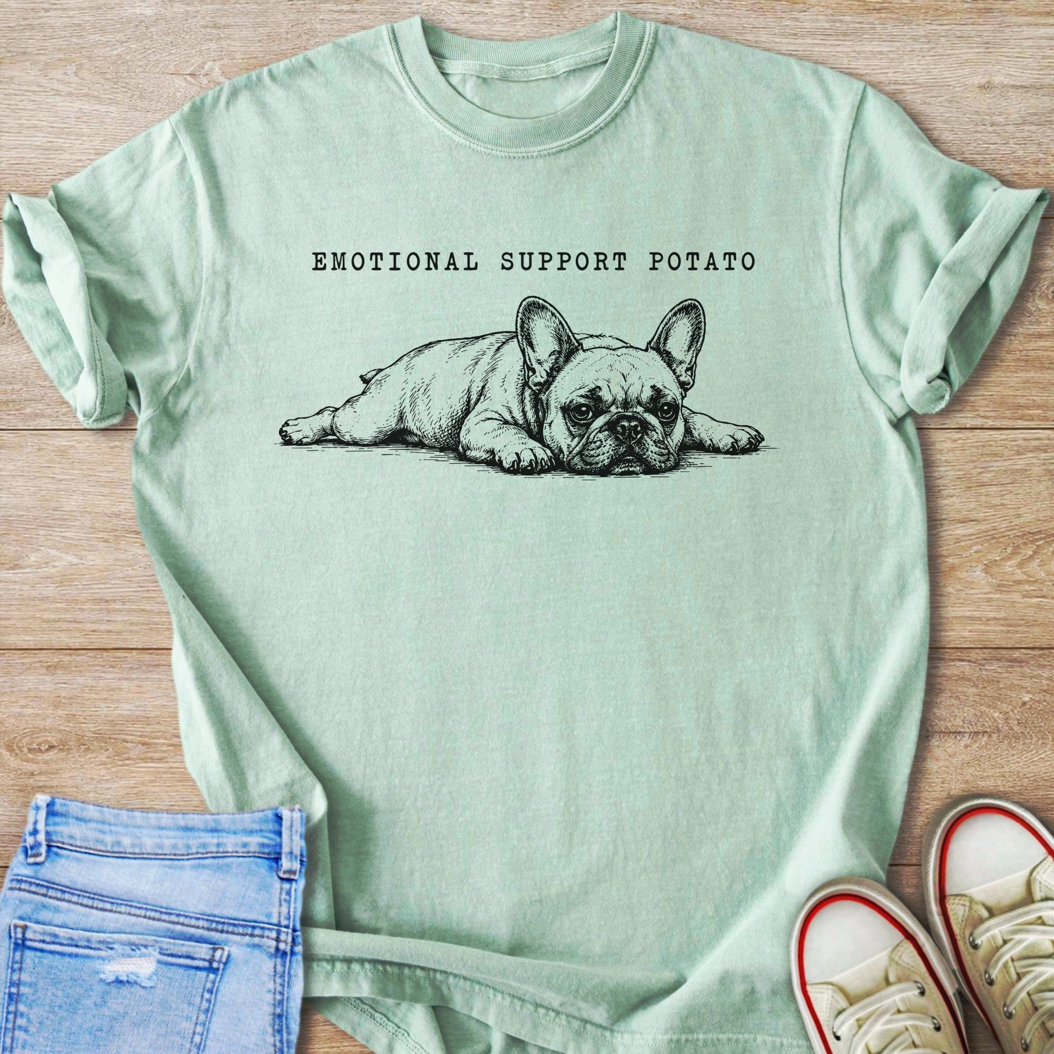 Light green t-shirt with a sketch of a French bulldog and text "EMOTIONAL SUPPORT POTATO".