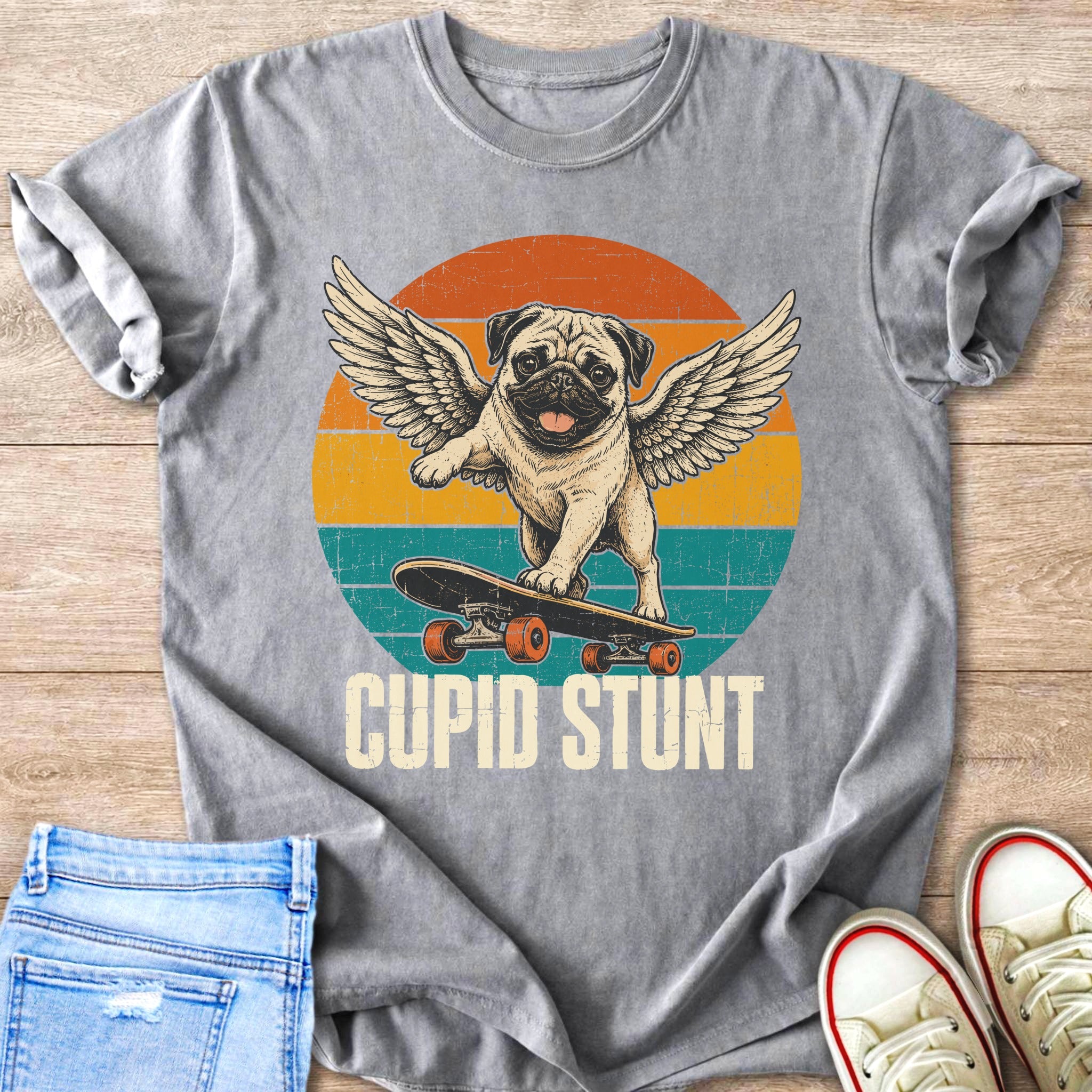 T-shirt graphic of a pug with wings skateboarding with text "CUPID STUNT".