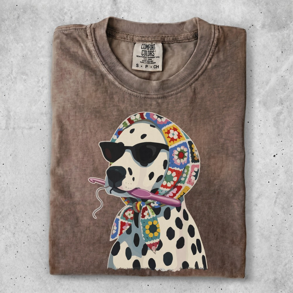 Dalmatian wearing sunglasses and a crochet scarf, holding a crochet hook.