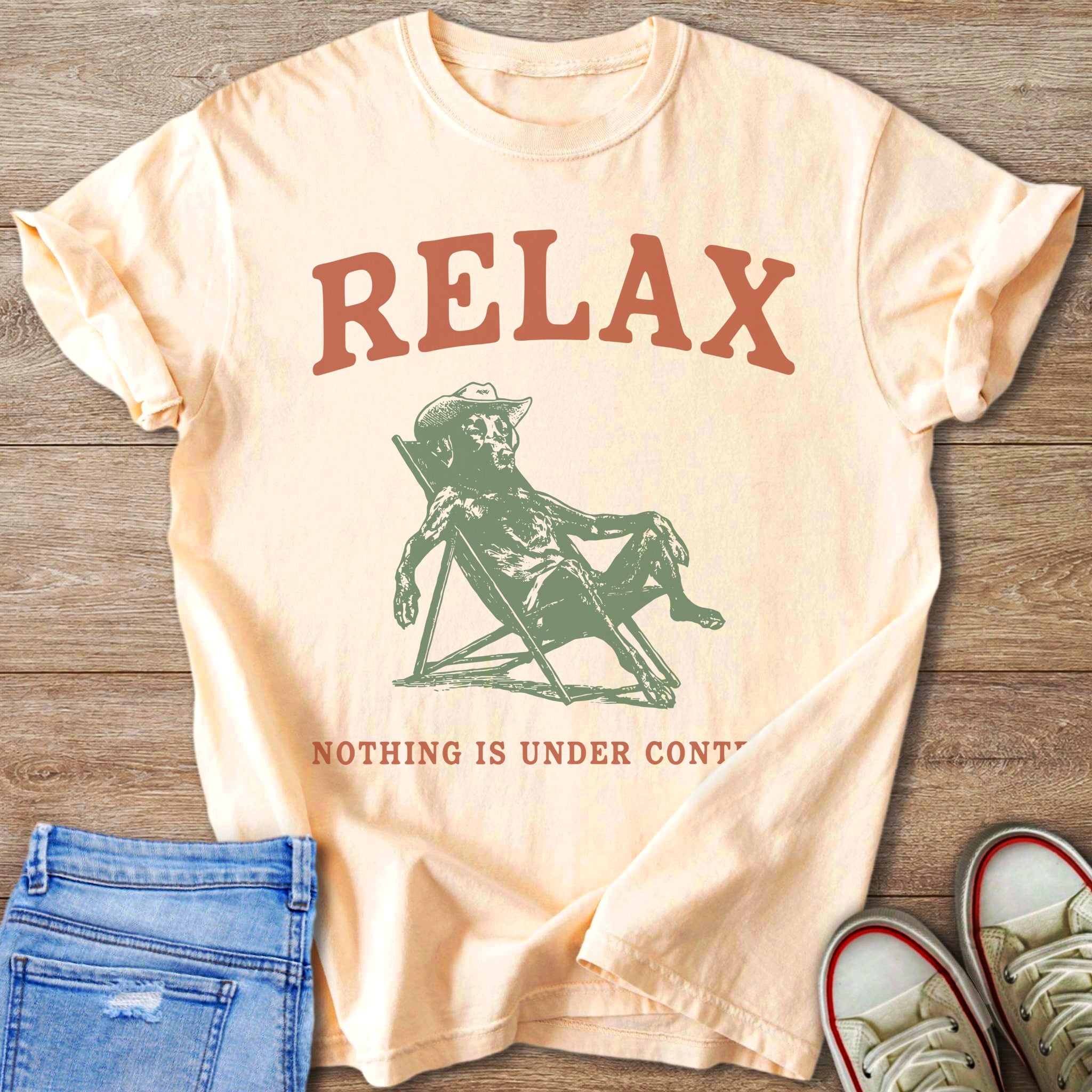 Peach t-shirt with "RELAX" and a dog sitting in a lounge chair.