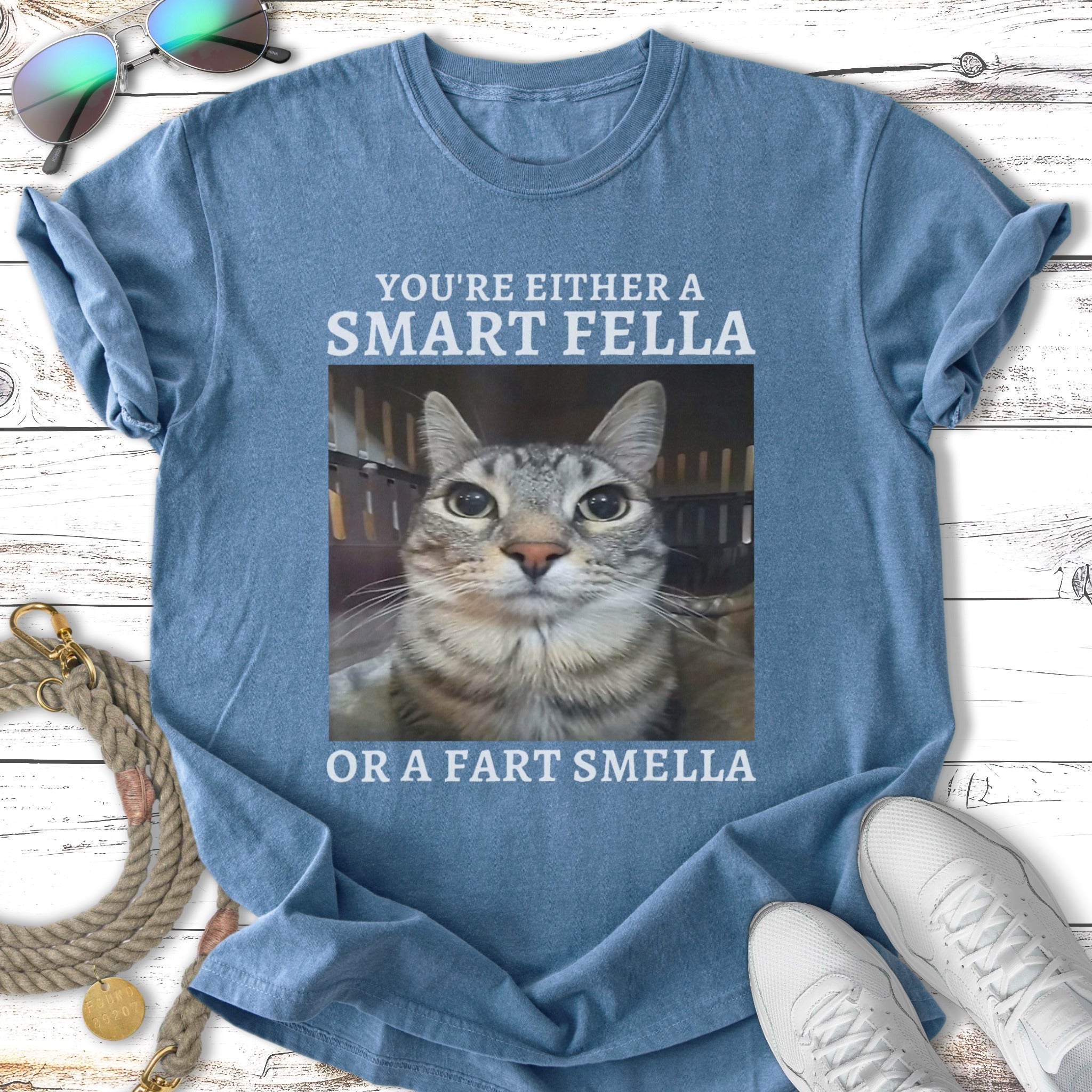 Blue t-shirt with text "You're Either A Smart Fella Or A Fart Smella" and a cat's face.