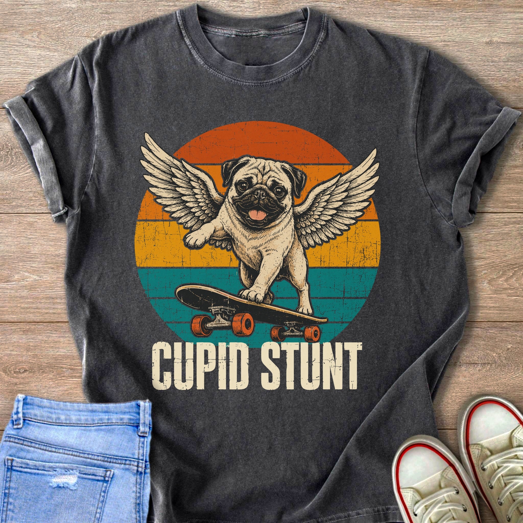 Pug with wings on skateboard, "CUPID STUNT" text, vintage sunset background.