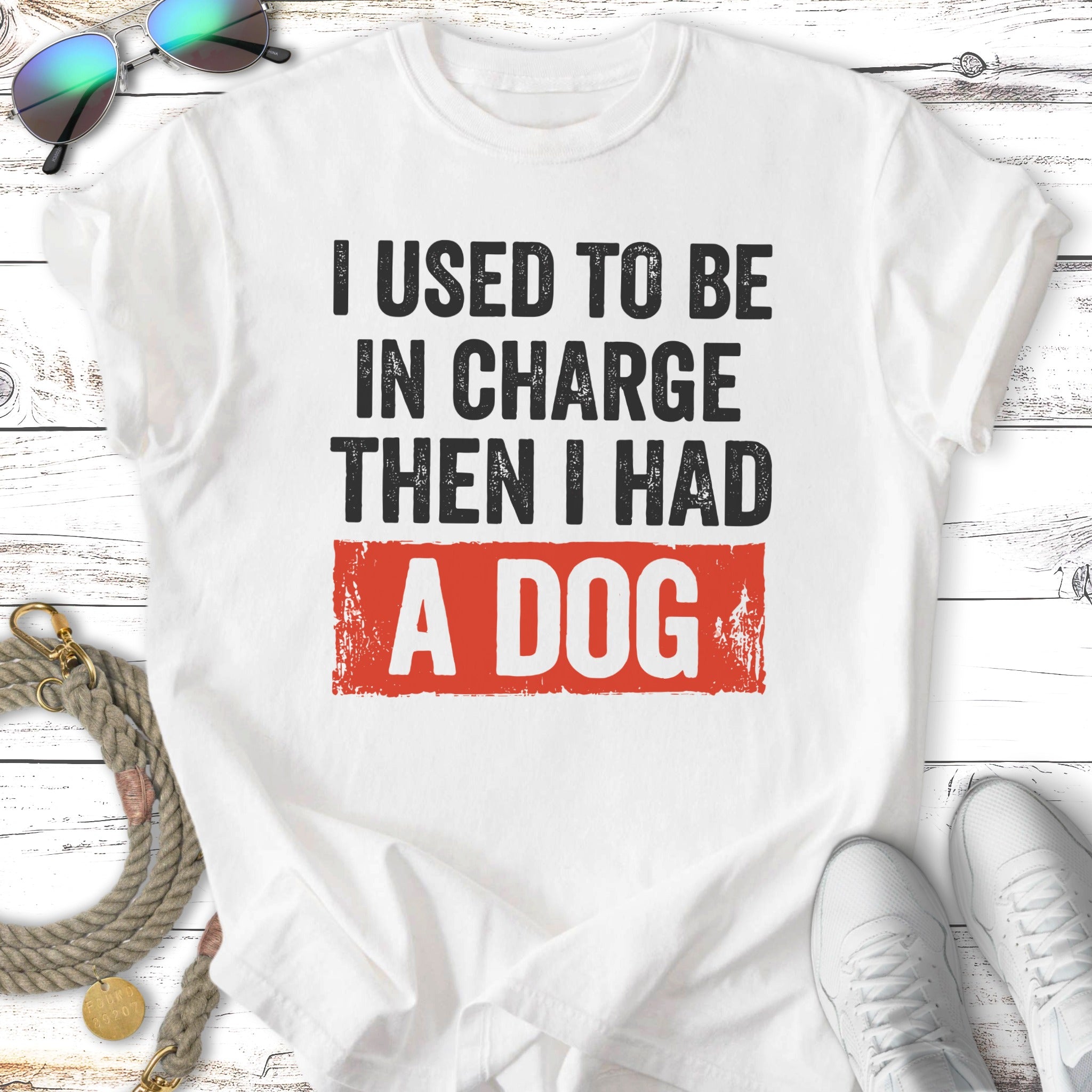 White t-shirt with "I used to be in charge then I had a dog" slogan.
