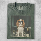 Dog wearing sunglasses sits beside champagne bottle and glass.