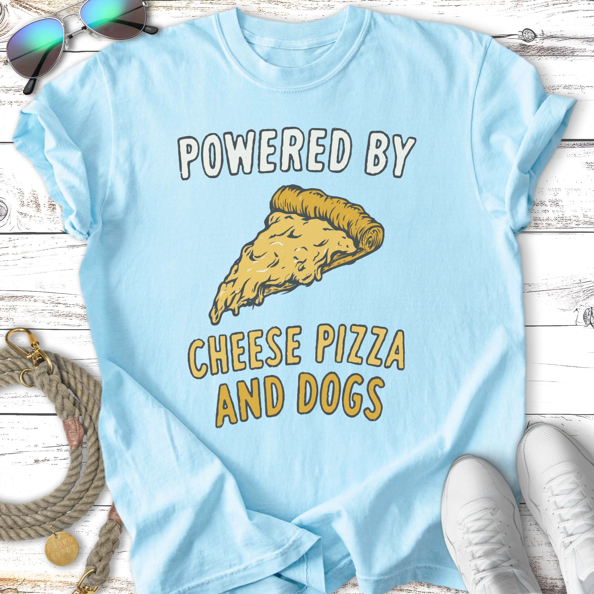 Light blue t-shirt with "Powered by Cheese Pizza and Dogs" graphic and pizza slice.