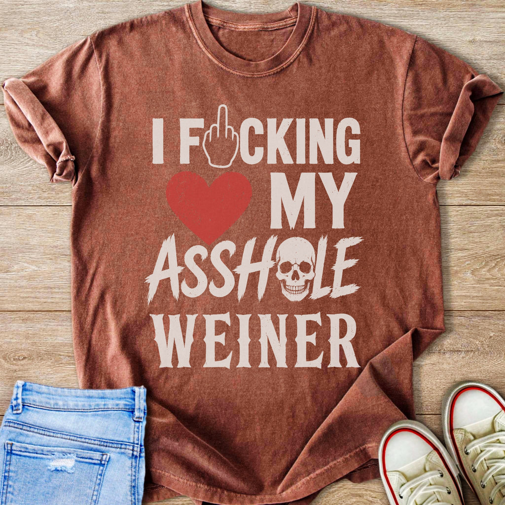 T-shirt with text "I FCKING MY ASSLOLE WEINER" and skull graphic.