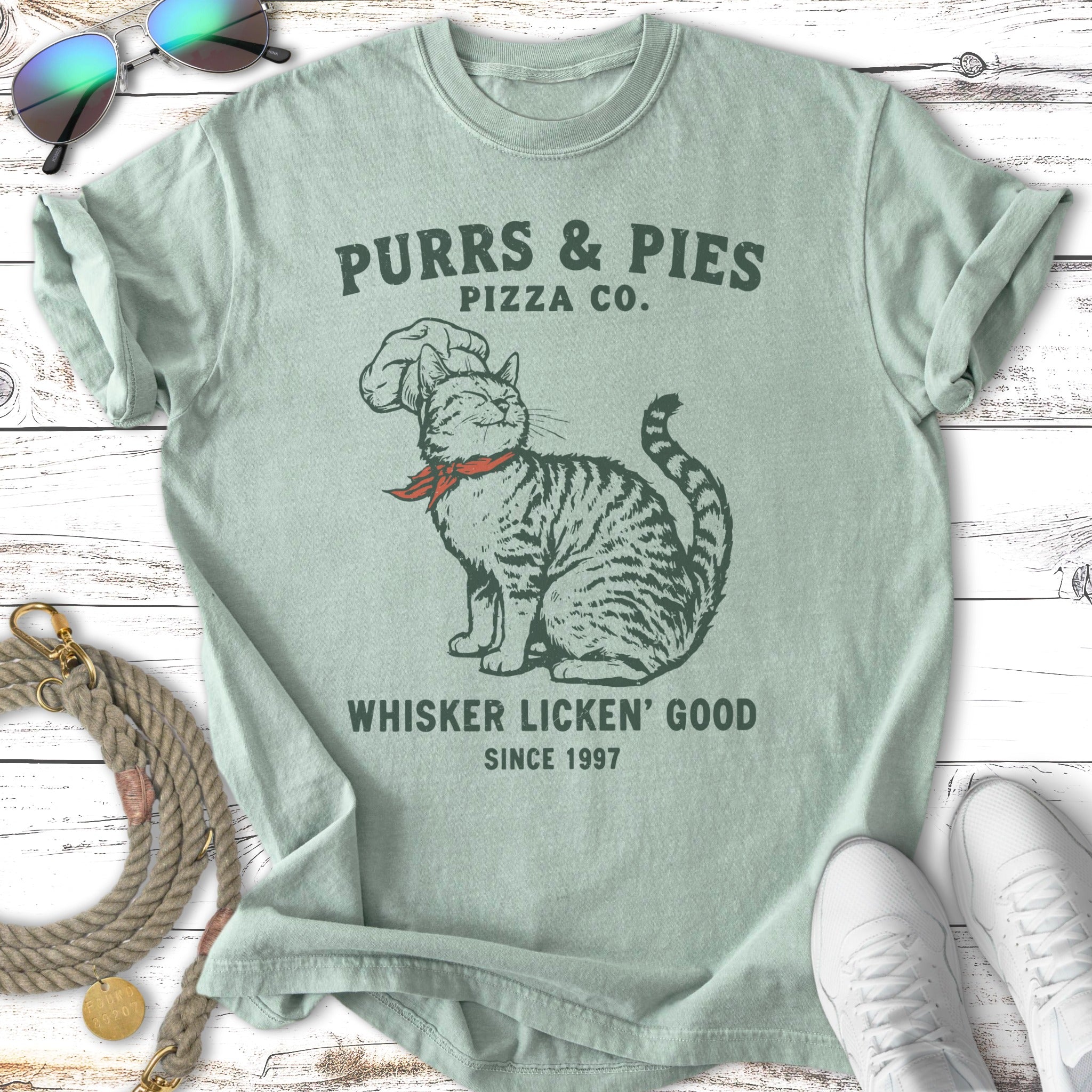 Cat wearing chef hat, "Purrs & Pies Pizza Co. Whiskers Licken' Good" text.