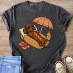 Dachshund in a hot dog bun with heart sunglasses under an umbrella, with sunscreen.