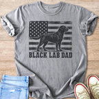Grey t-shirt with black lab silhouette in front of distressed American flag and "BLACK LAB DAD" text.