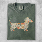 Green t-shirt with a dachshund silhouette filled with floral patterns.