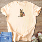 Peach t-shirt with a print of a German Shepherd holding the American flag.