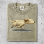 T-shirt with a painted image of a fluffy tan dog running.