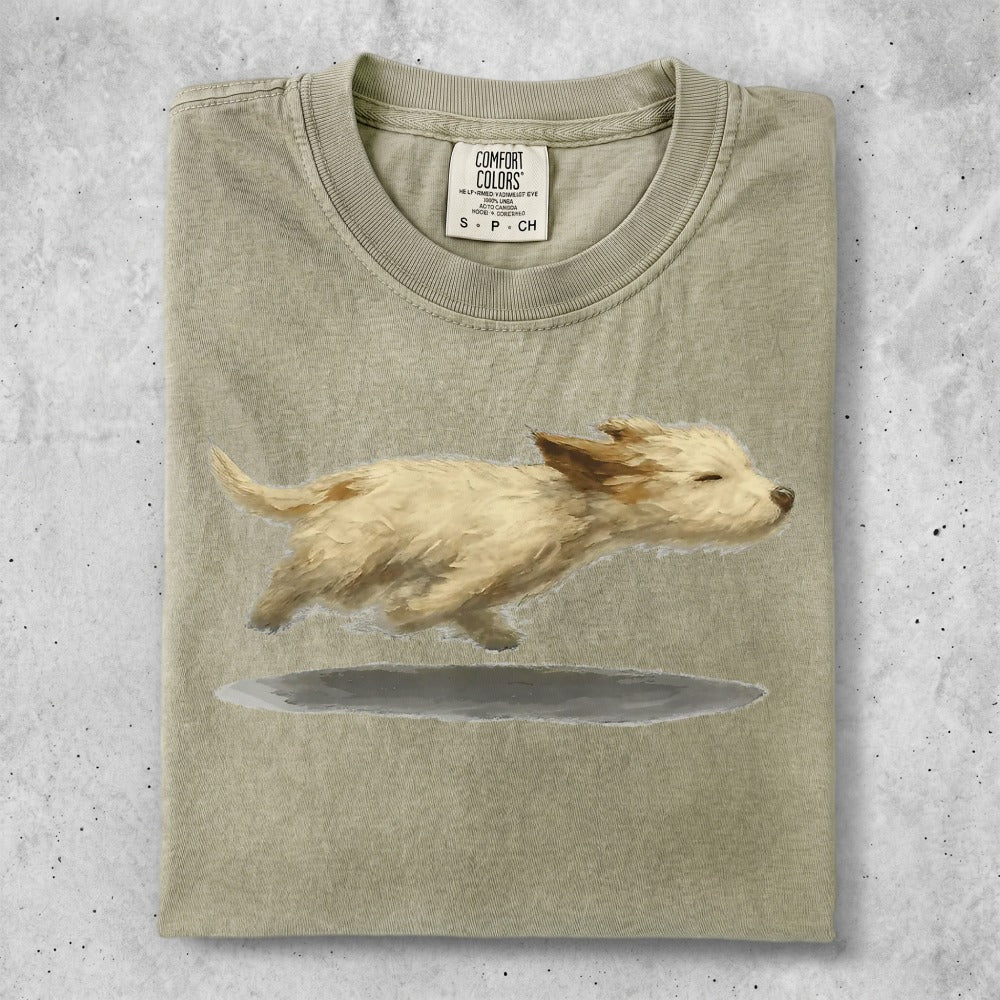 T-shirt with a painted image of a fluffy tan dog running.