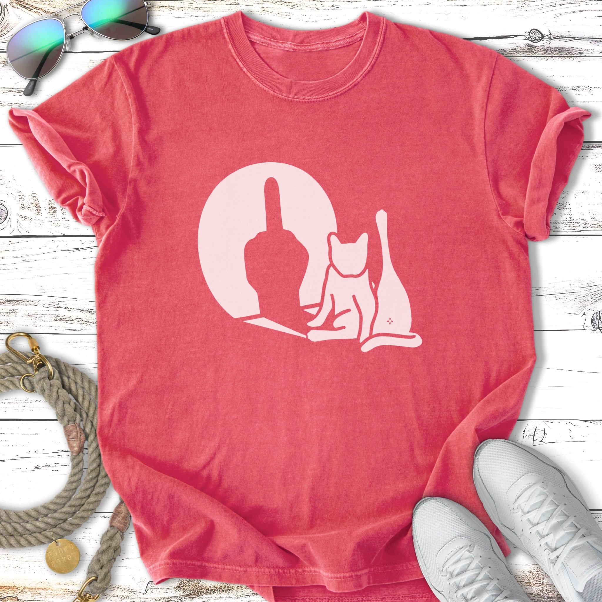 T-shirt with a white graphic of a cat and a middle finger against a circular background.