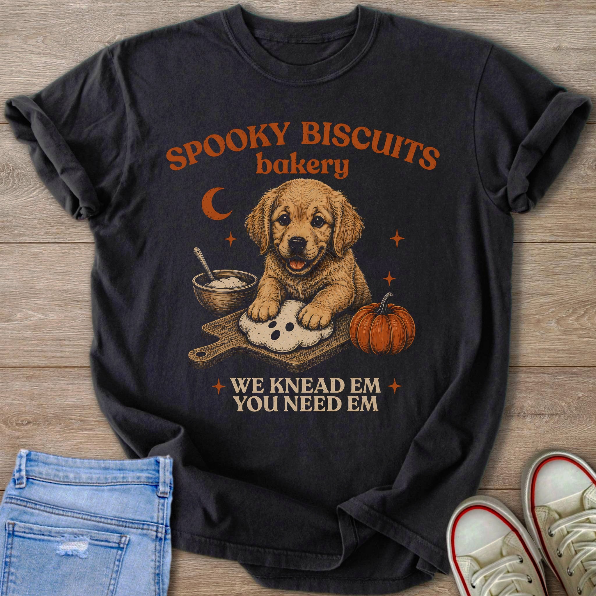 T-shirt with Golden Retriever puppy kneading dough, pumpkin, and text "Spooky Biscuits Bakery".