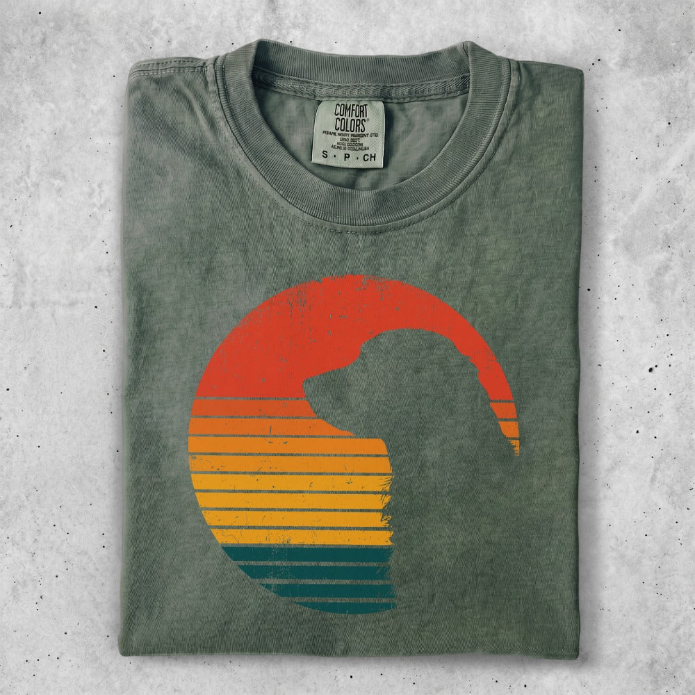 Olive green t-shirt with a silhouette of a dog inside a sunset graphic.