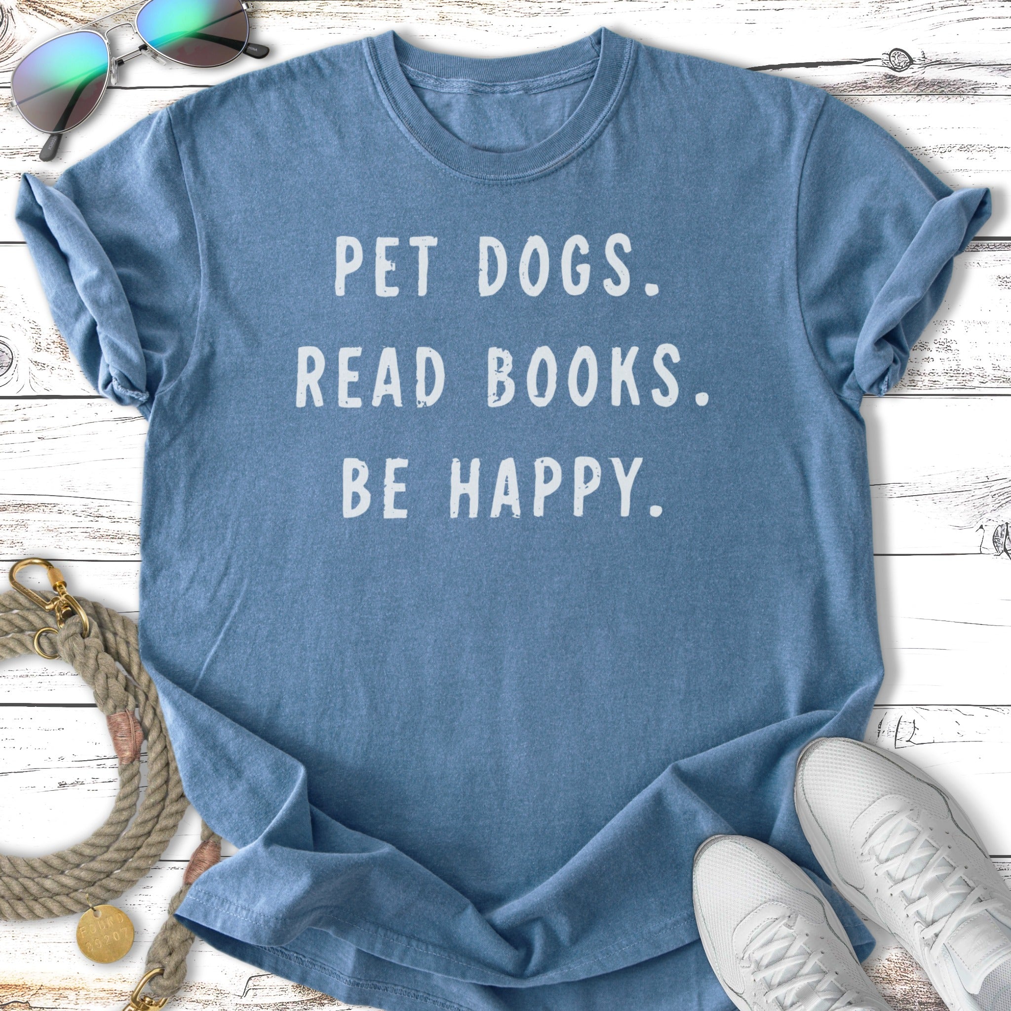 Blue t-shirt with "PET DOGS. READ BOOKS. BE HAPPY." printed on it.