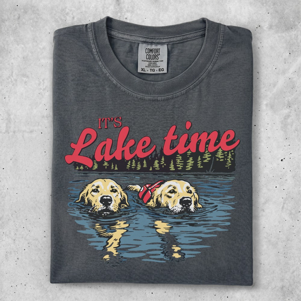 Two golden retrievers wearing life vests swim in a lake with "It's Lake time" text.