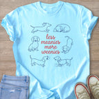 Light blue t-shirt with cartoon dachshunds and text reading "less meanies more weenies."