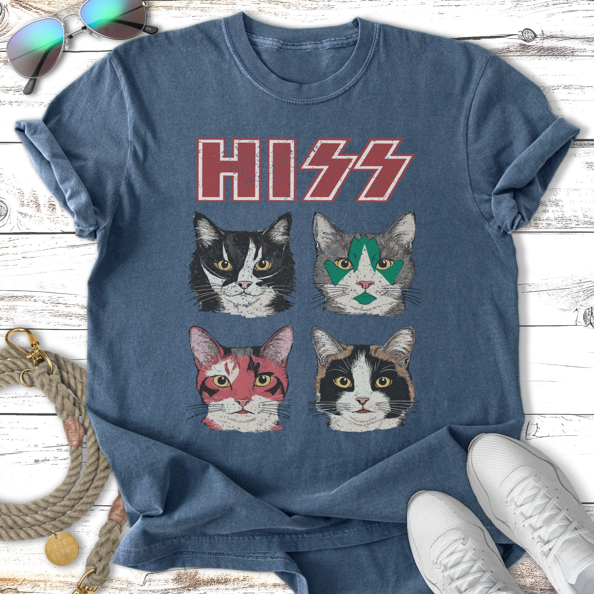 Four cat faces with painted makeup, with "HISS" in red above them.