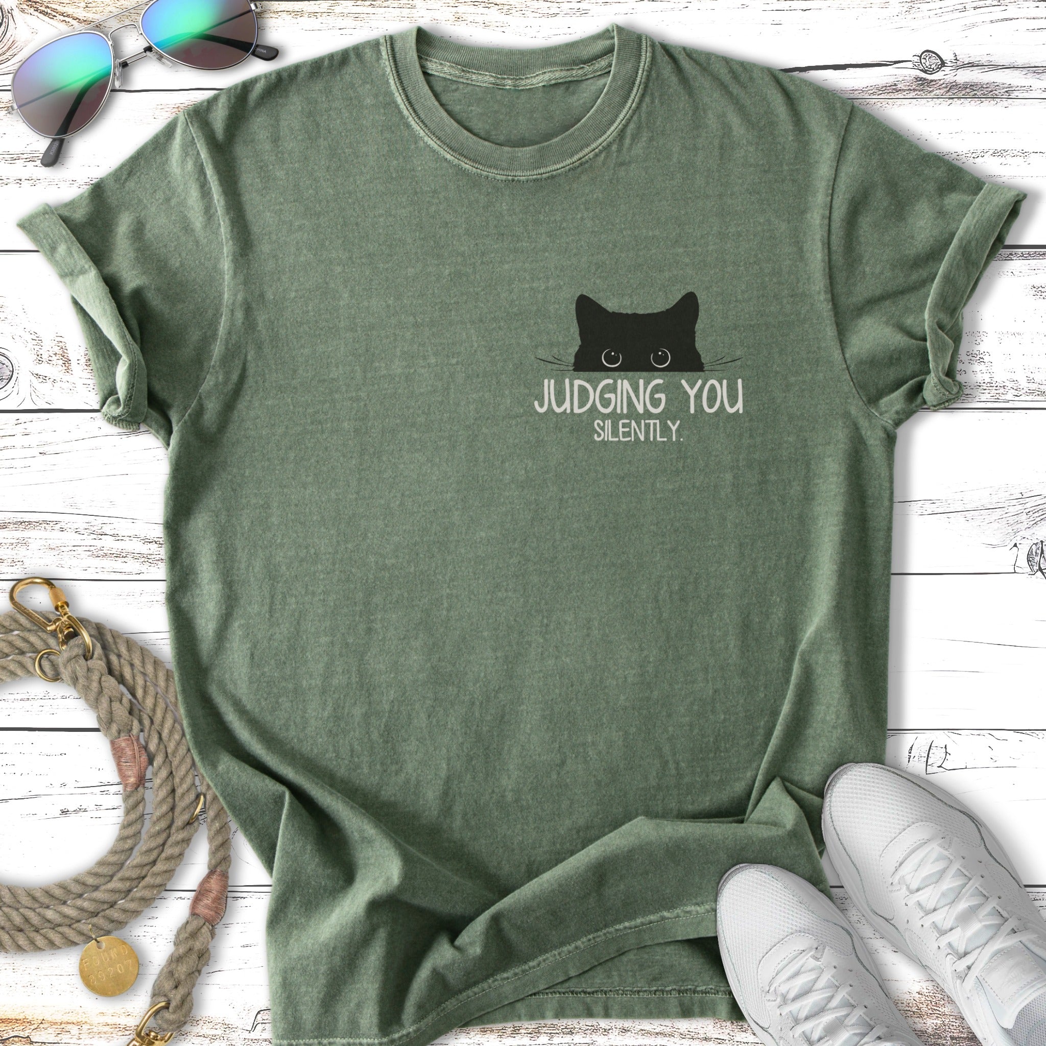 Green t-shirt with a black cat peeking over the pocket, reading "JUDGING YOU SILENTLY."