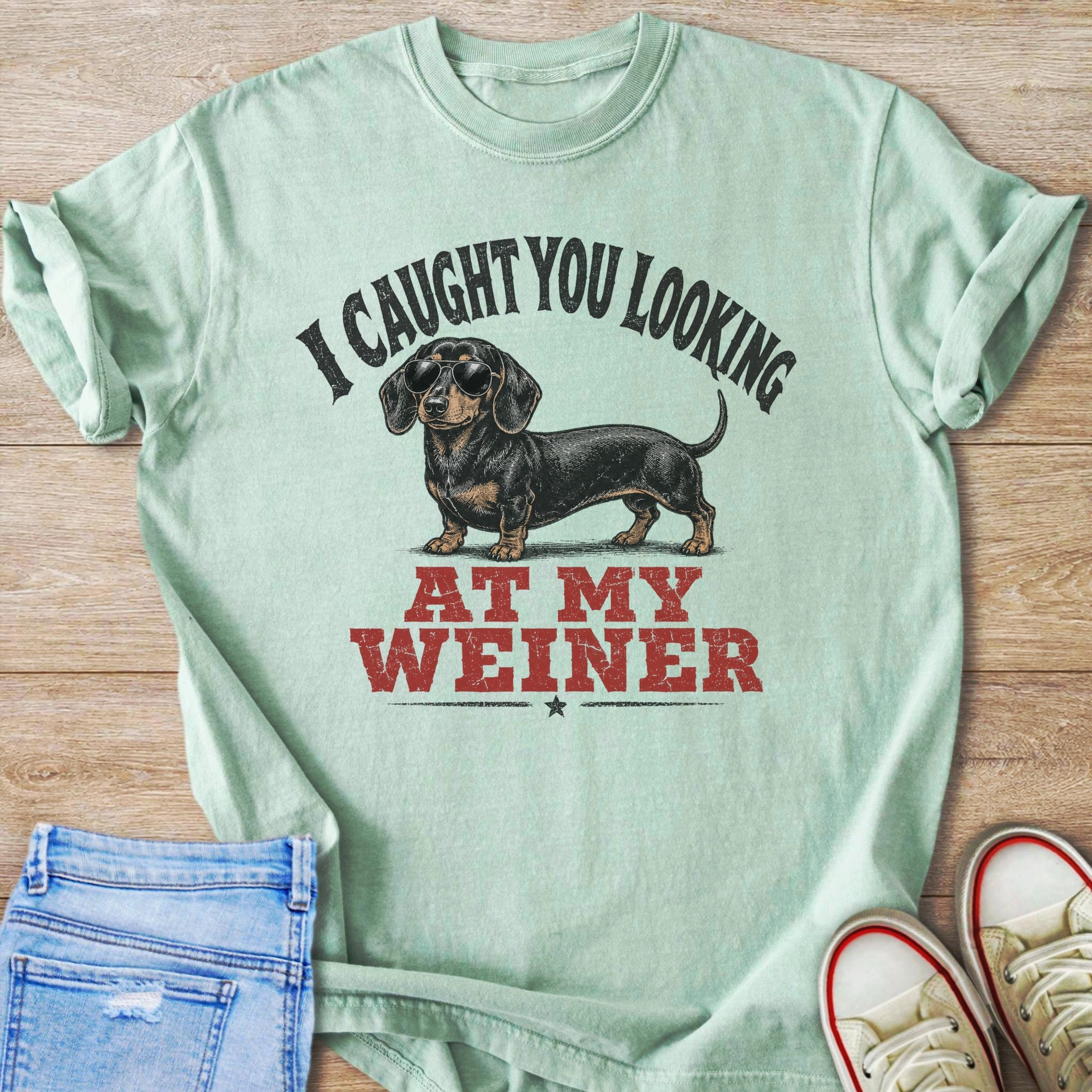 Mint t-shirt with a dachshund wearing sunglasses and text "I CAUGHT YOU LOOKING AT MY WEINER".