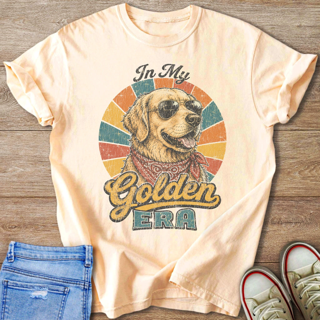 Peach t-shirt with distressed graphic of a golden retriever wearing sunglasses and bandana, text "In My Golden Era".