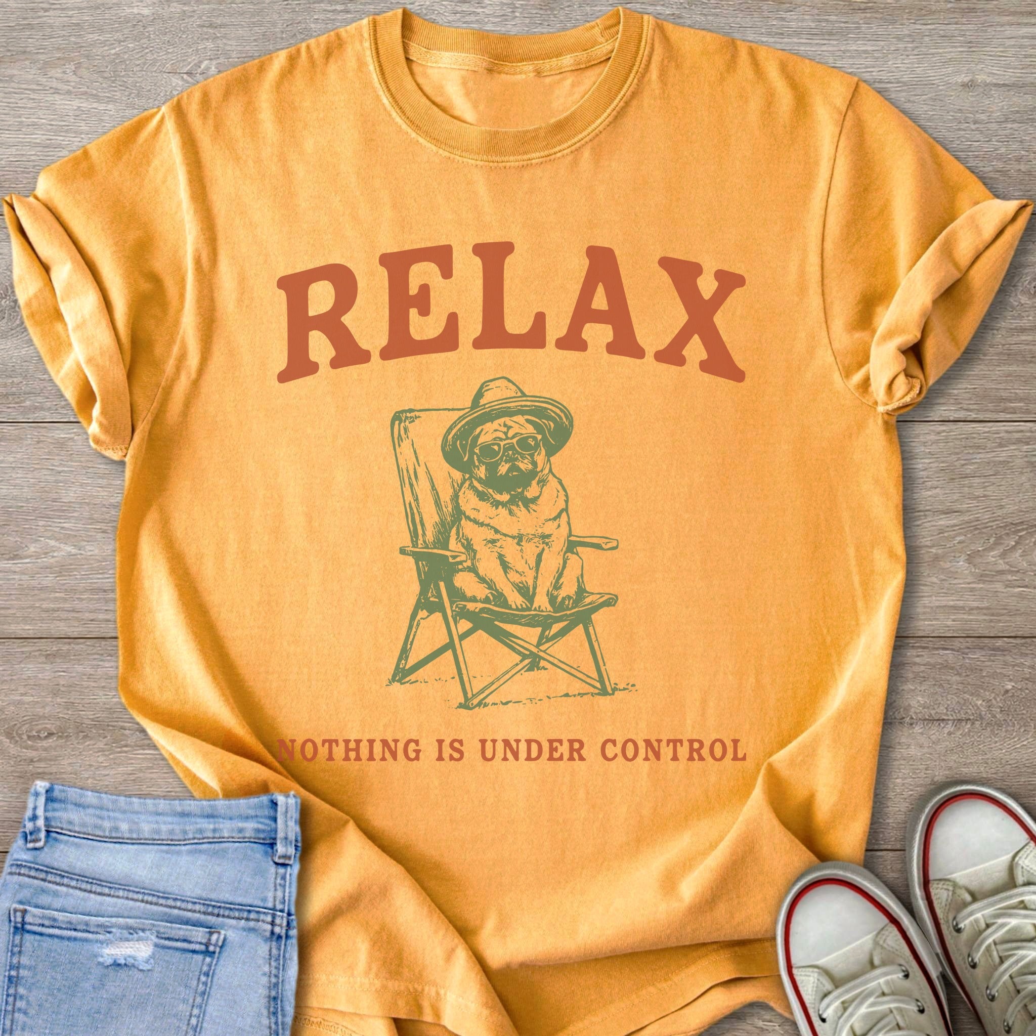 Orange t-shirt with text "RELAX" and a pug on a chair.