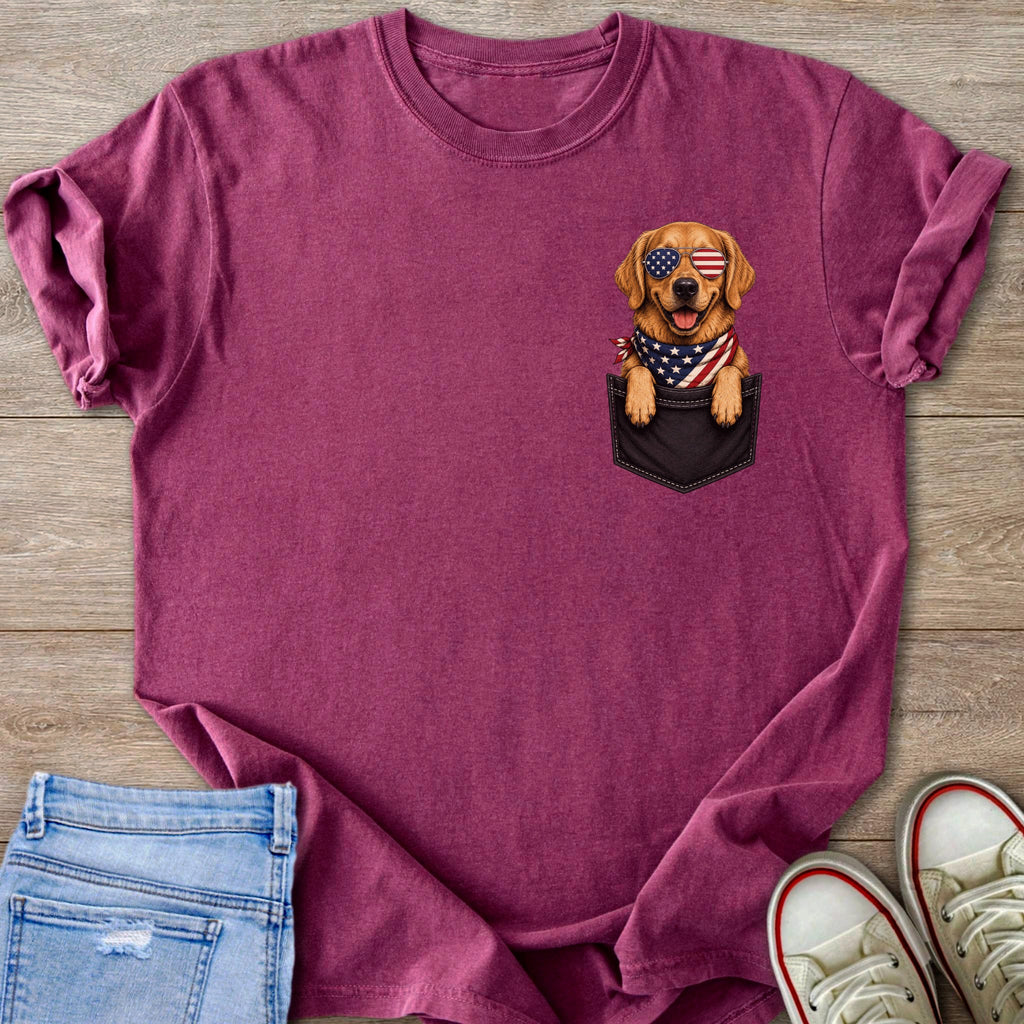 Golden Retriever dog wearing American flag sunglasses and bandana peeking from pocket.