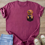 Golden Retriever dog wearing American flag sunglasses and bandana peeking from pocket.