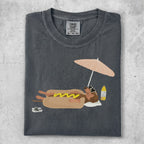 T-shirt with graphic of a hot dog on a beach umbrella.