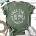 Green t-shirt with "Fur Dad The Man The Myth The Snack Dealer" text and paw prints.