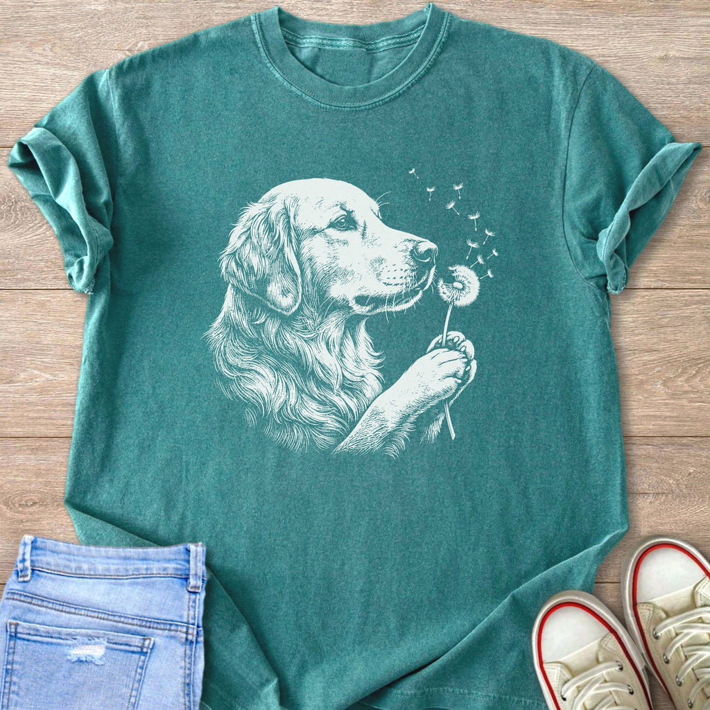 Teal t-shirt with white line drawing of a golden retriever blowing dandelion seeds.