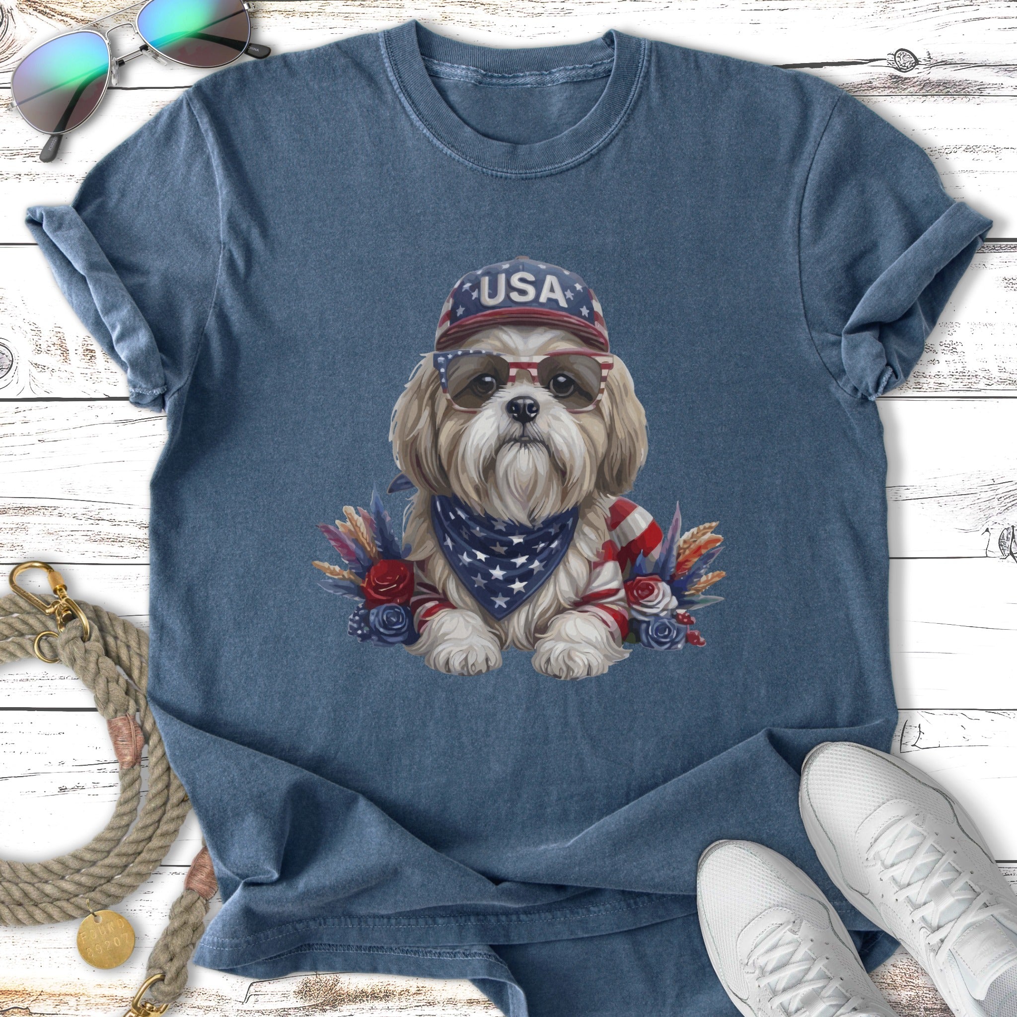 Dog wearing sunglasses and USA bandana, adorned with patriotic floral accents.