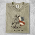 Golden retriever holds American flag with "250 YEARS 1776-2026" text.