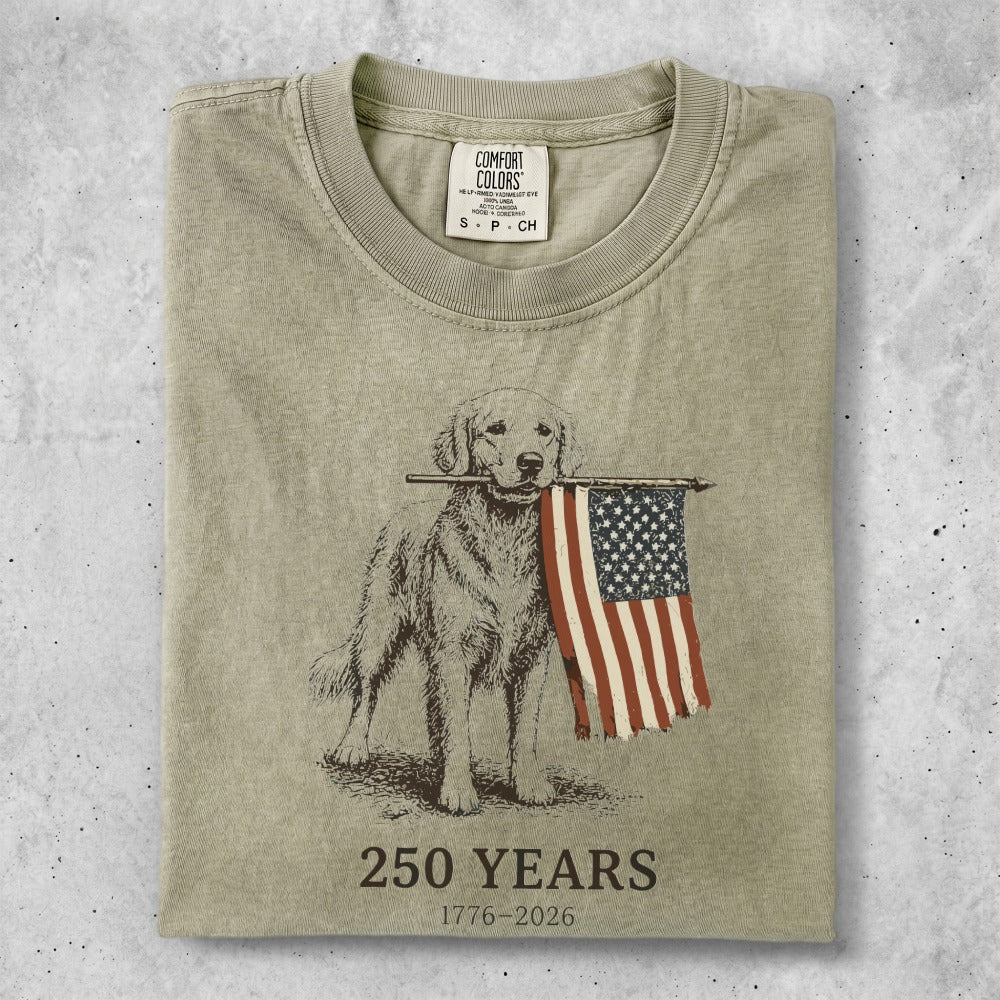 Golden retriever holds American flag with "250 YEARS 1776-2026" text.