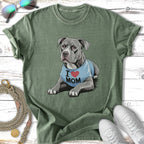Pitbull wearing an "I Love Mom" shirt with a heart, on a green t-shirt.