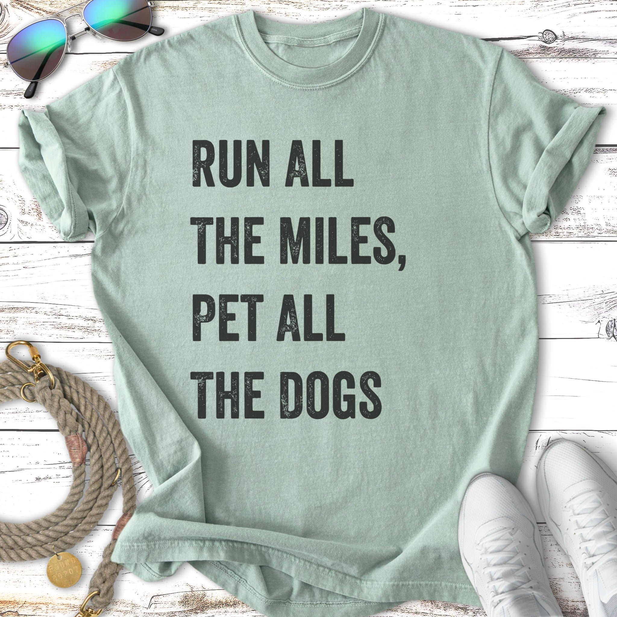 Light mint green t-shirt with "Run all the miles, pet all the dogs" text.