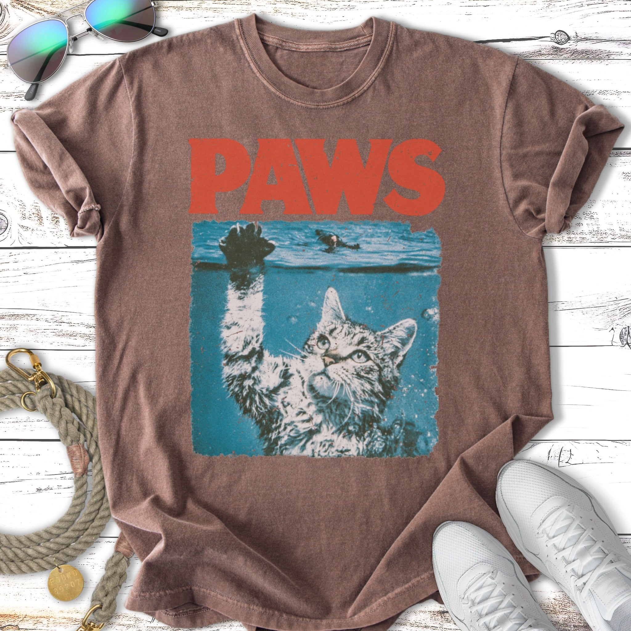Cat reaching out of water with "PAWS" text above.