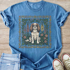 Blue t-shirt with a Cavalier King Charles Spaniel illustration framed by flowers and ivy.