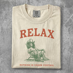 Cream t-shirt with "RELAX" and a person in a chair graphic.