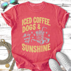 Iced coffee, dogs, and sunshine graphic on a coral t-shirt with sunglasses and sneakers.