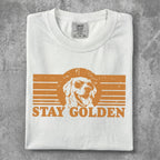White t-shirt with "STAY GOLDEN" and a dog wearing sunglasses graphic.
