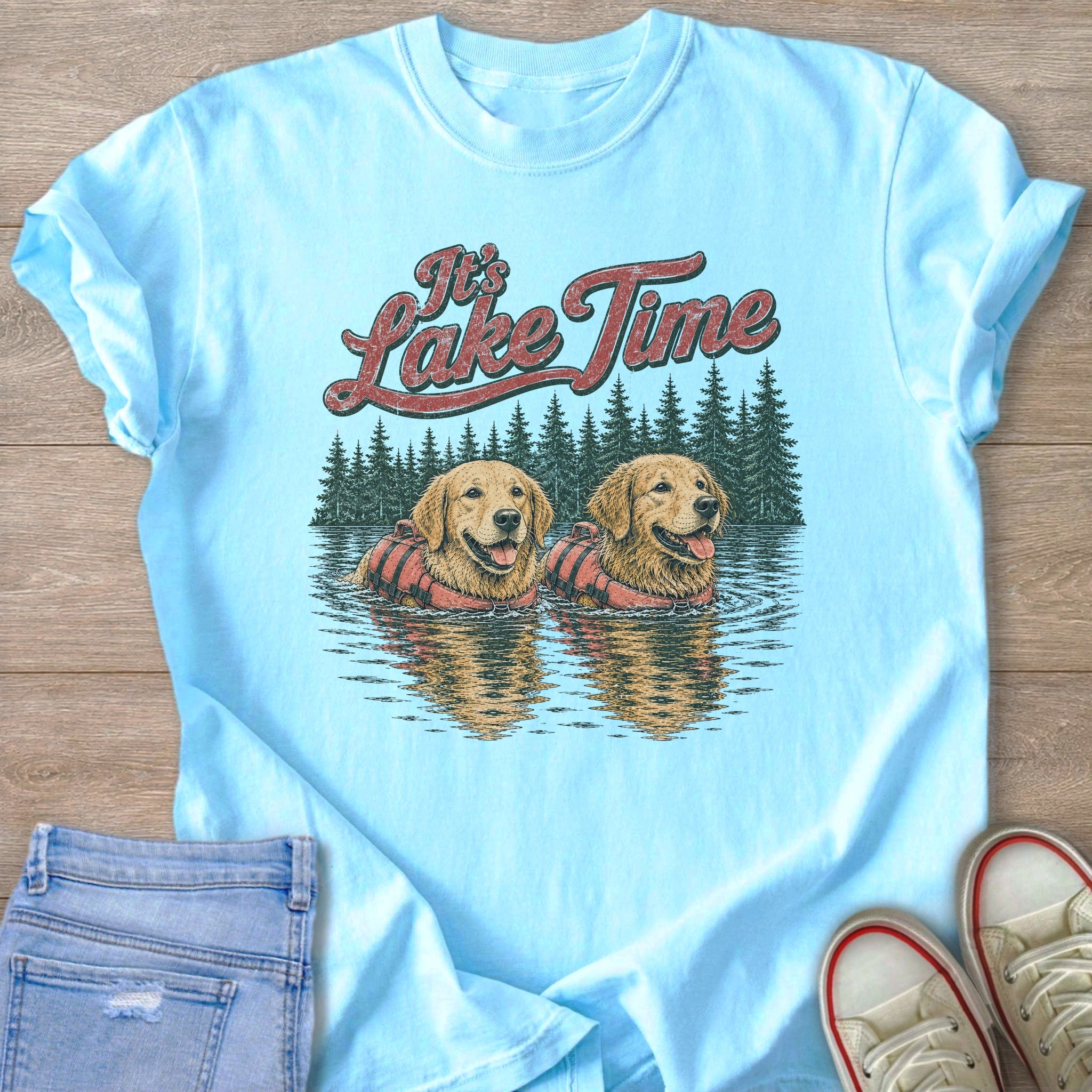 Light blue t-shirt graphic with two golden retrievers in life vests and text "It's Lake Time".