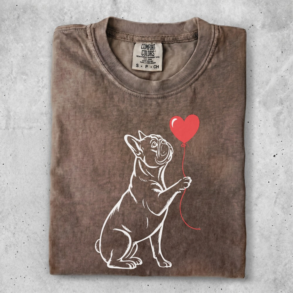Line art French bulldog holding a red heart balloon, on a brown t-shirt.